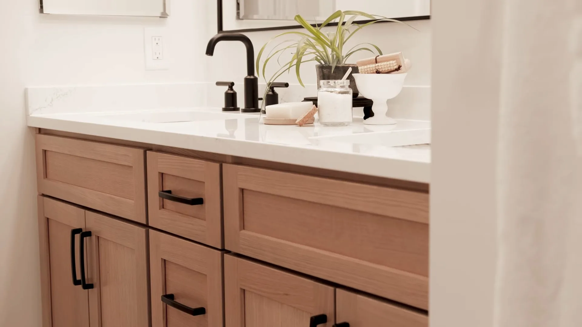 A finished bathroom vanity with a sink and closed cabinet doors, the plumbing hidden behind them