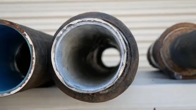 Cut ends of large iron pipe with a smooth white liner visible inside one of them