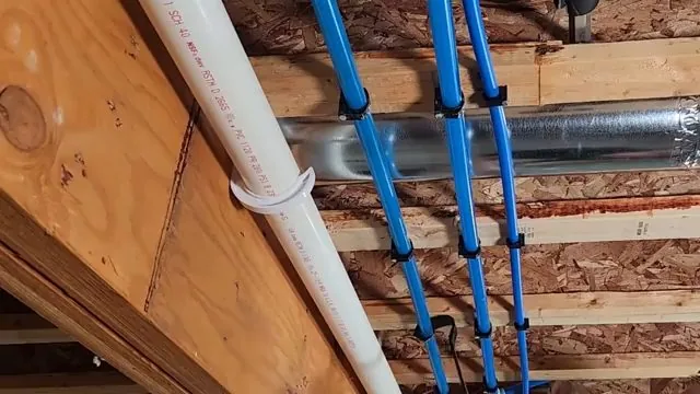 Blue PEX water lines clipped along wooden joists beside a white drain pipe
