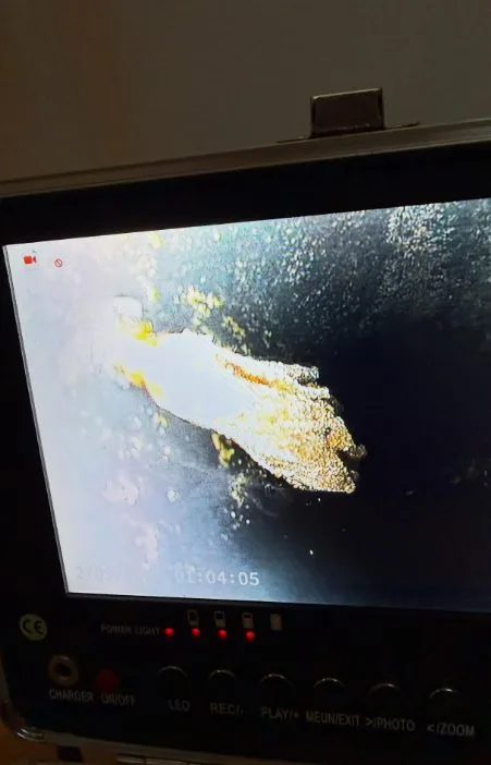 A camera monitor showing a bright patch against a dark background where a leak is being located